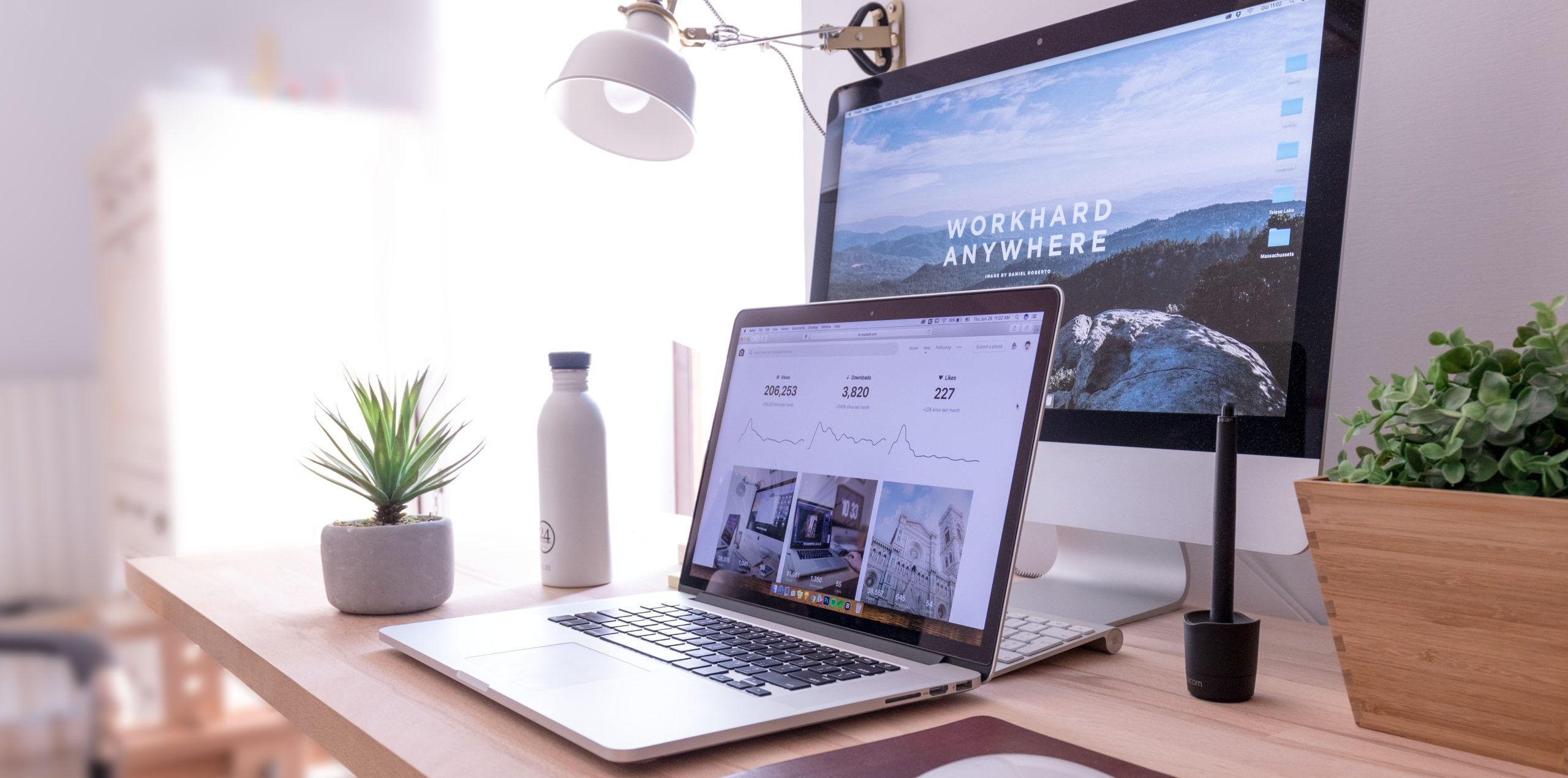 MacBook Pro on table beside white iMac and Magic Mouse